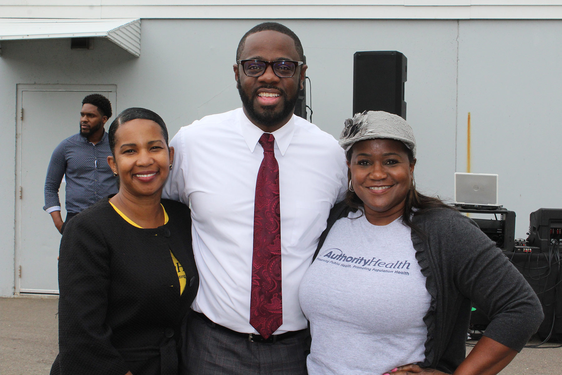 Three people smiling and posing for a photo outdoors.