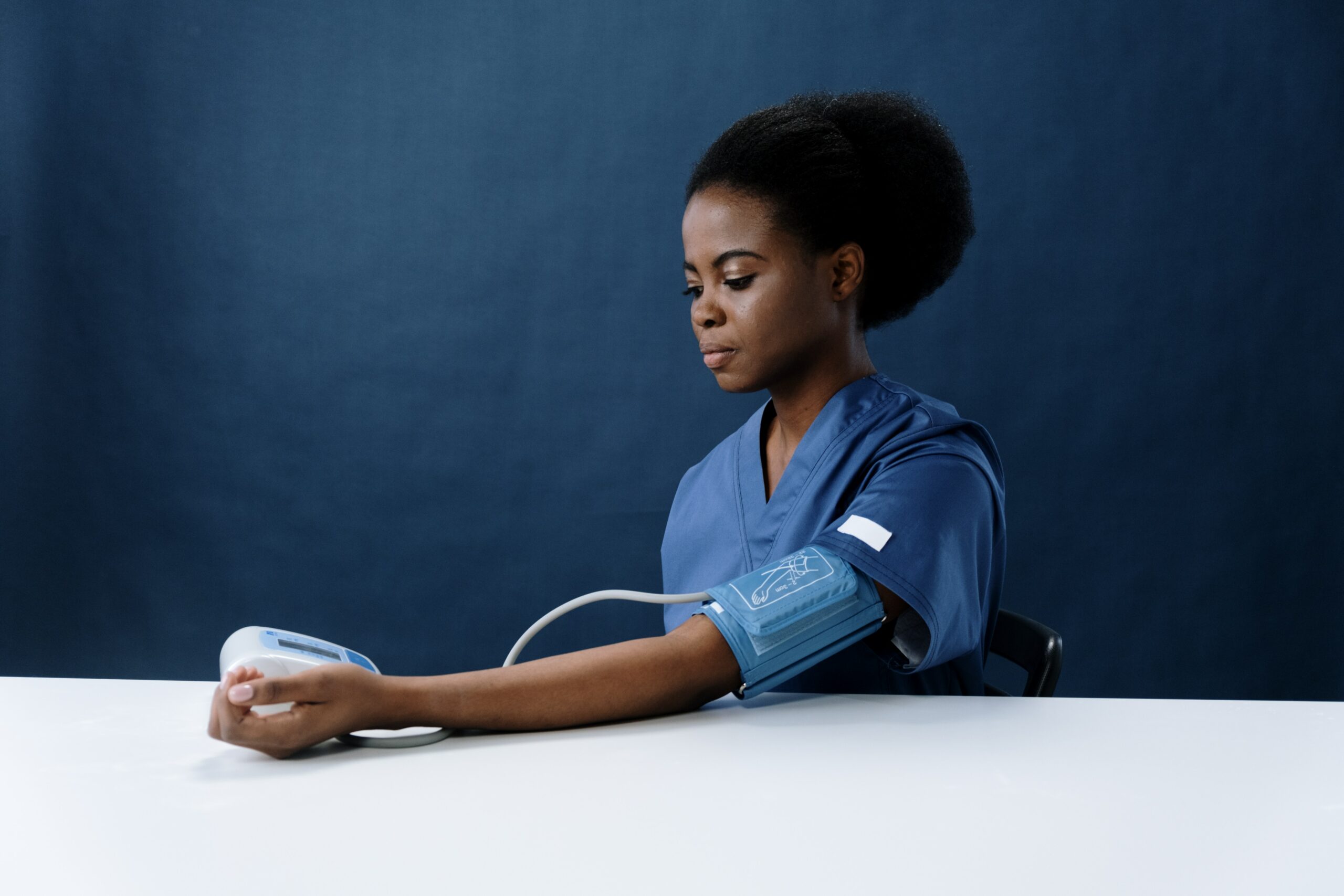 Nurse checking blood pressure using a digital monitor.