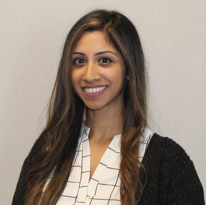 Professional headshot of a smiling woman with long hair.
