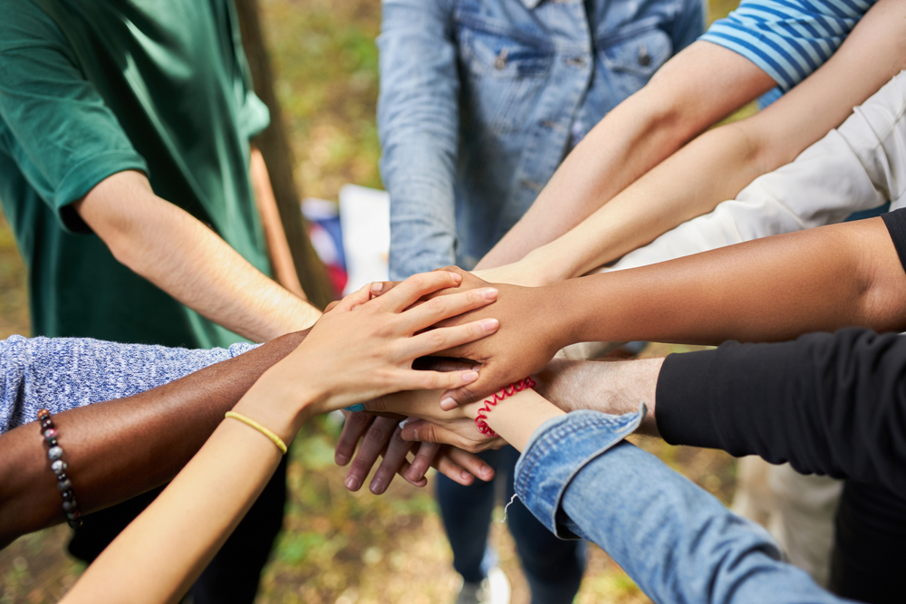Multiple hands stacked together symbolizing unity and teamwork.
