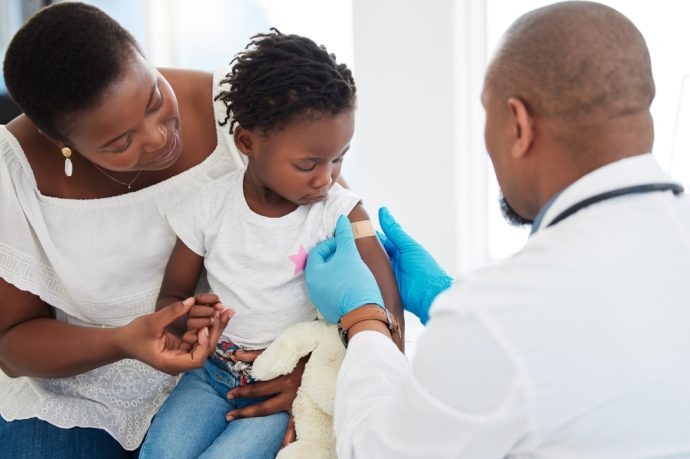 A child receives a vaccination from a healthcare professional.