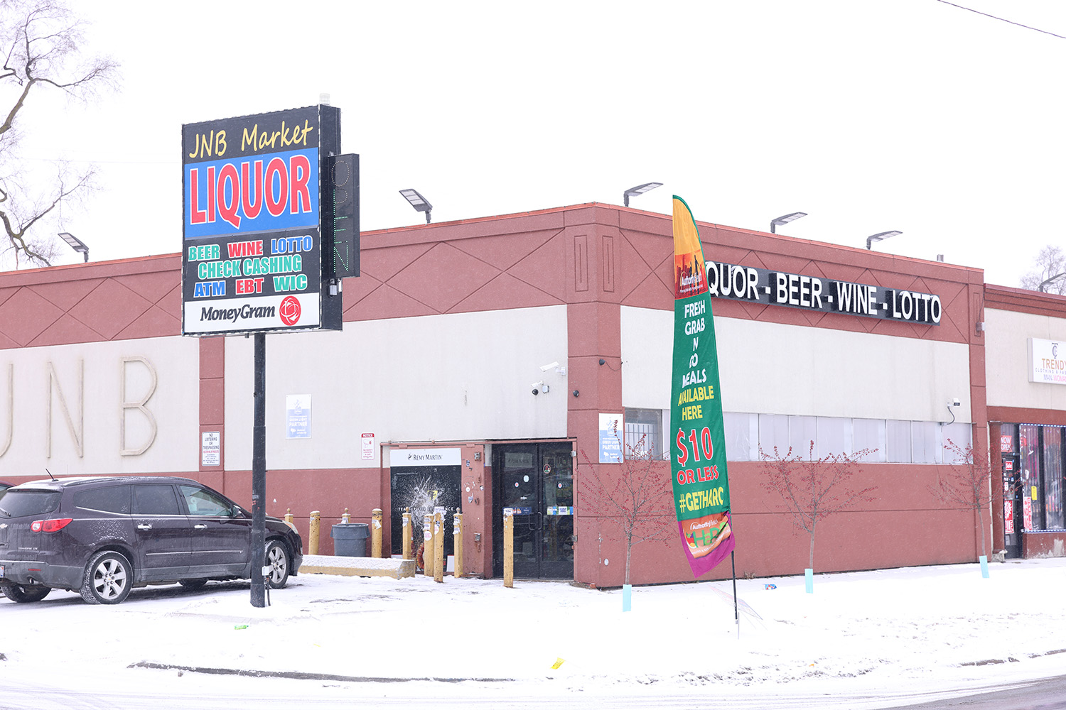 A liquor store with signage on a snowy day.