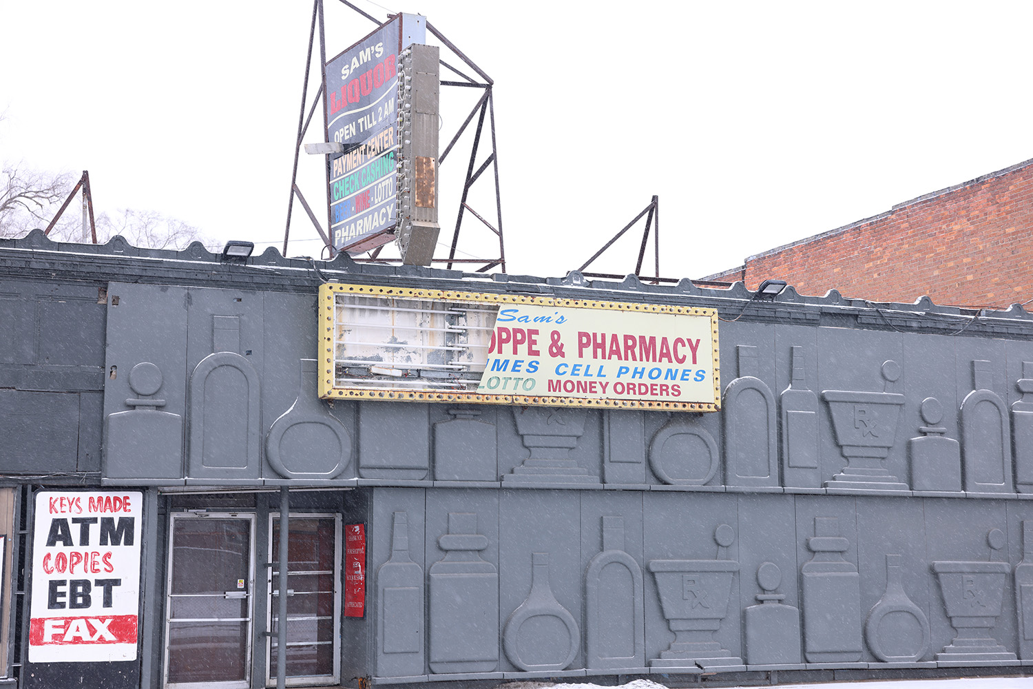Gray building with a PPE & Pharmacy sign and a marquee.