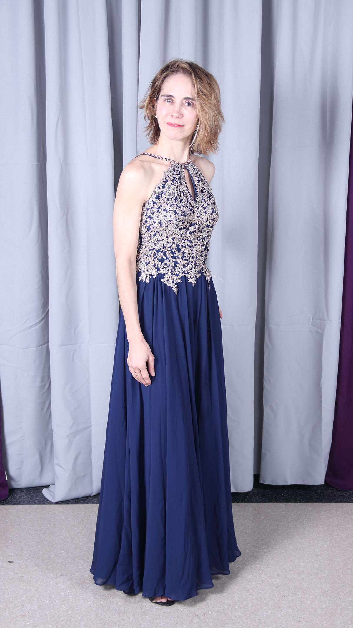 Elegant woman in a navy blue and beige formal gown.