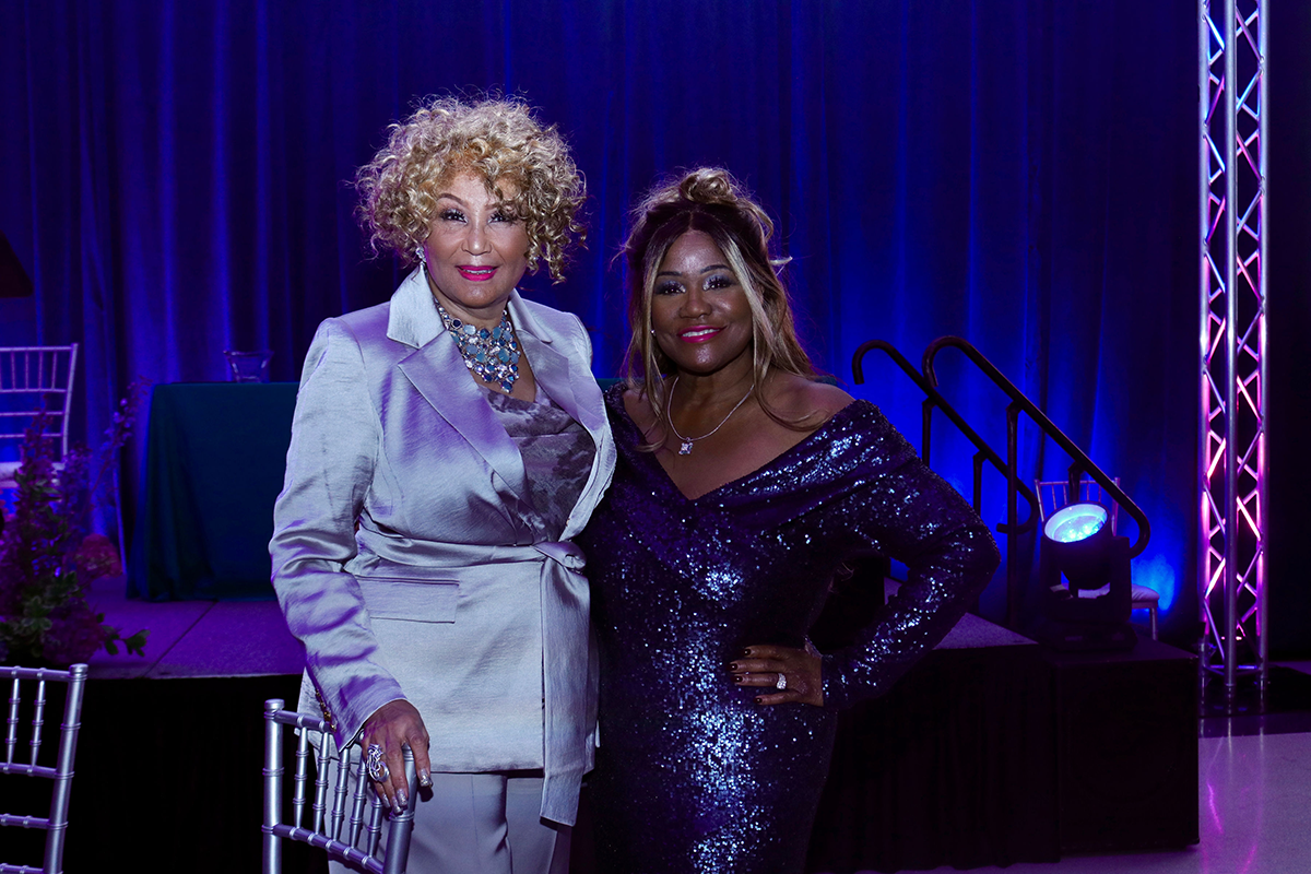 Two elegantly dressed women posing at an evening event.