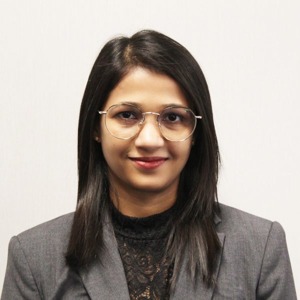 Professional woman in glasses and business attire smiling.