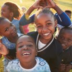 Smiling children playing together on sunlit grass